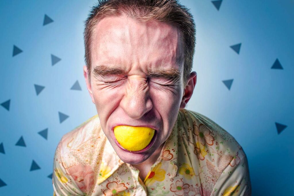 un homme mange un citron dans sa bouche